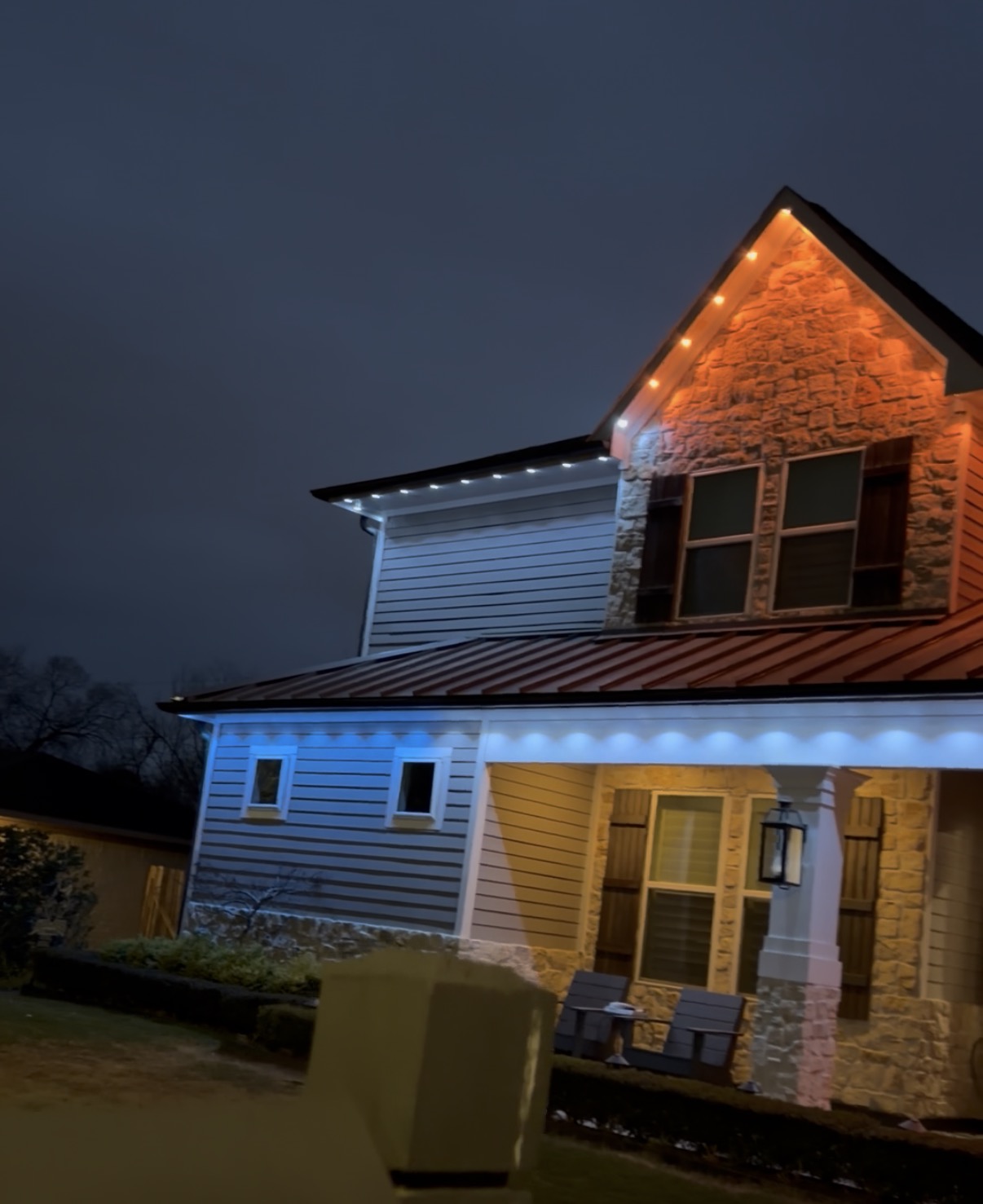 Warm and cool white permanent LED lighting on a stone and siding home