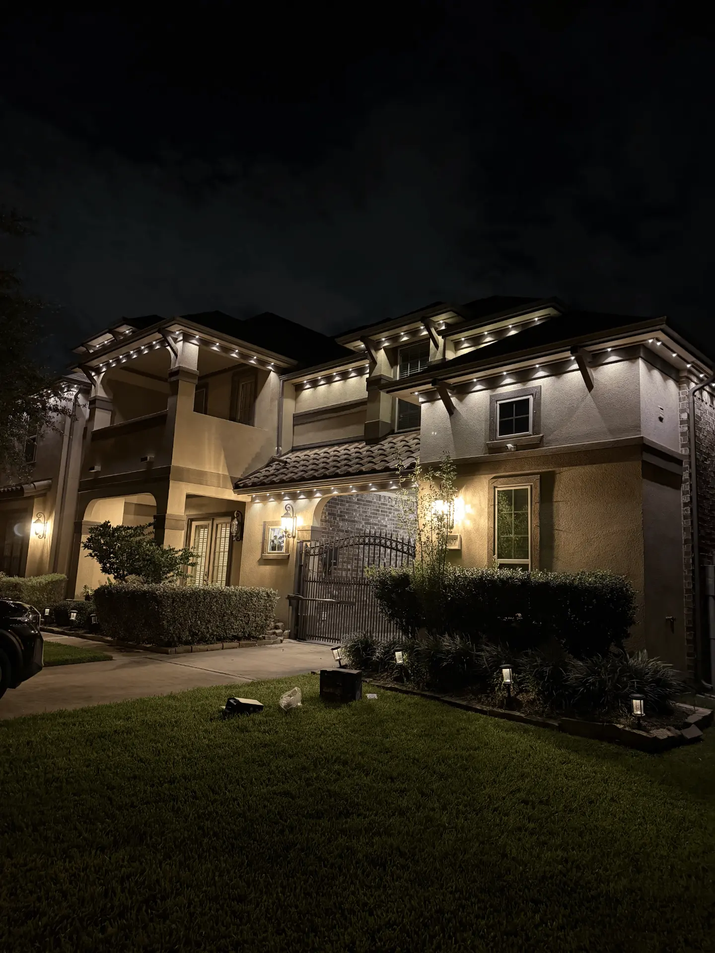 Warm white permanent LED roofline lighting on a Houston stucco home