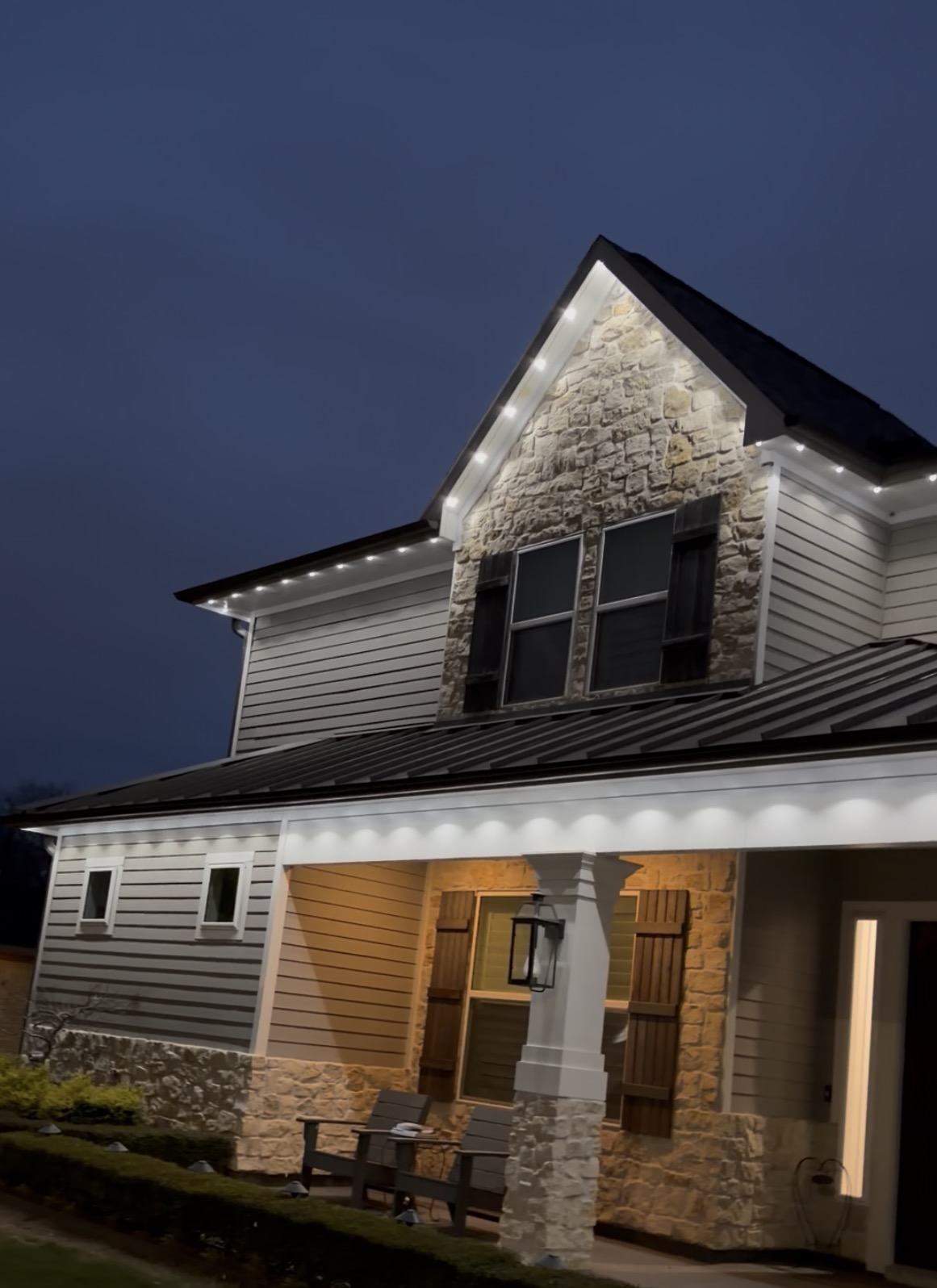 Cool white permanent LED lighting along the roofline of a Woodlands home